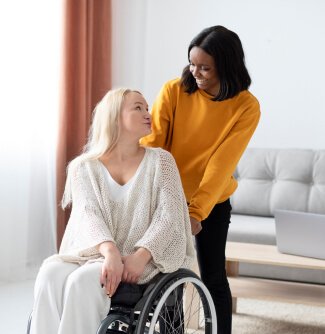 A caregiver assisting a woman in wheelchair