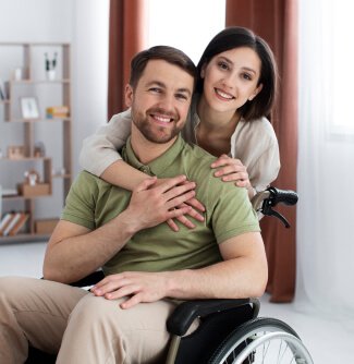 woman comforting man in a wheelchair