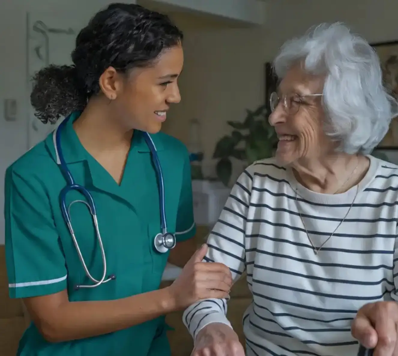 A compassionate nurse with a stethoscope supporting a smiling elderly woman using a mobility walker, offering professional specialized care for senior independence at home.